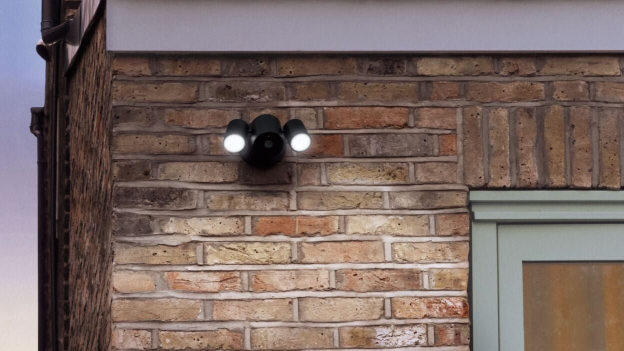 apple home collection security camera on brick wall at sunset